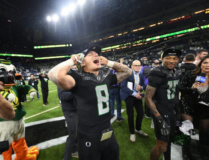 Oregon Ducks quarterback Dillon Gabriel (8) celebrates defeating the Penn State Nittany Lions to win the Big Ten Championship in the 2024 Big Ten Championship game at Lucas Oil Stadium.