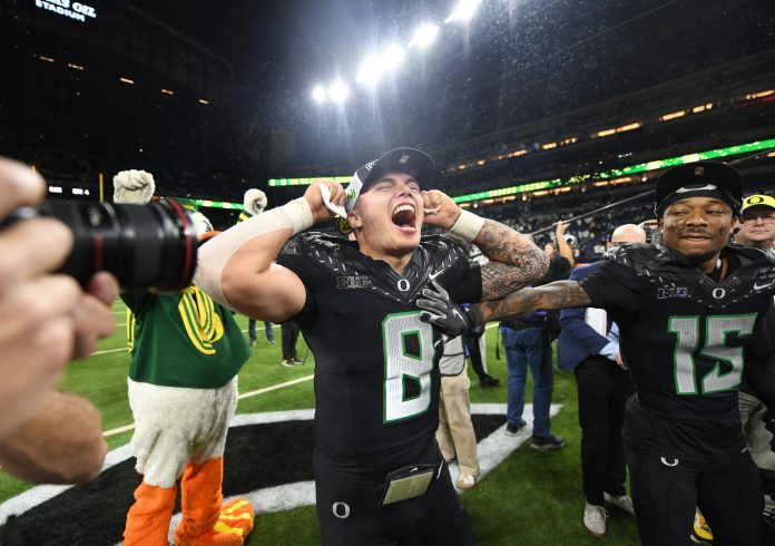 Oregon Ducks quarterback Dillon Gabriel (8) and wide receiver Tez Johnson (15) celebrate defeating the Penn State Nittany Lions to win the Big Ten Championship in the 2024 Big Ten Championship game at Lucas Oil Stadium.