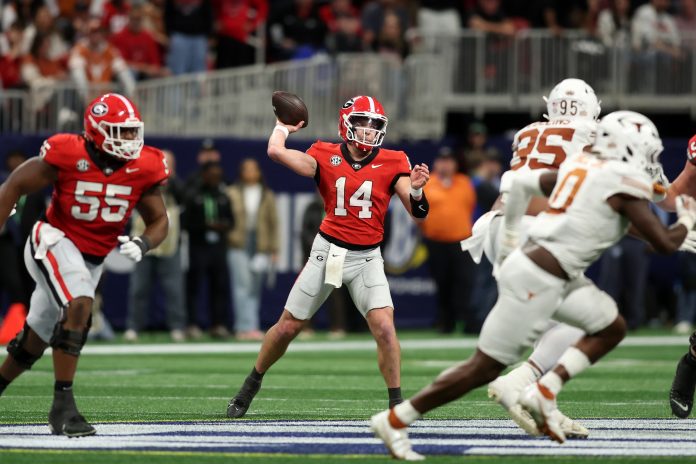 Georgia Bulldogs quarterback Gunner Stockton (14) drops back to pass against the Texas Longhorns during the second half in the 2024 SEC Championship game at Mercedes-Benz Stadium.