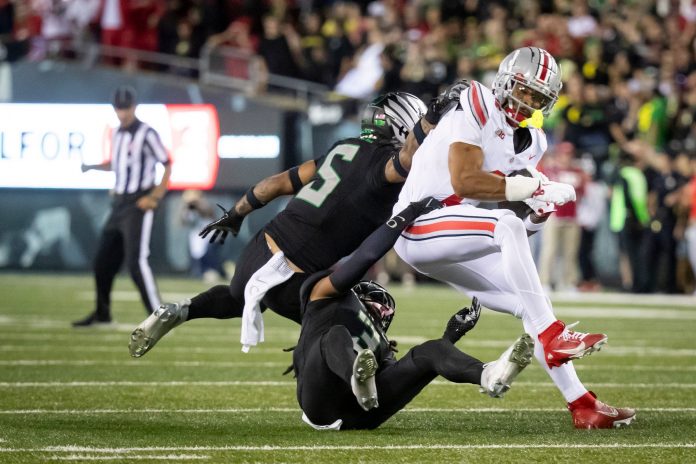 Oregon Ducks defensive back Brandon Johnson and Oregon Ducks defensive back Kobe Savage trip up Ohio State Buckeyes wide receiver Emeka Egbuka as the No. 3 Oregon Ducks host the No. 2 Ohio State Buckeyes Saturday, Oct. 12, 2024 at Autzen Stadium in Eugene, Ore.