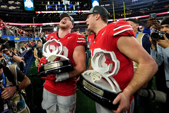 Ohio State Buckeyes quarterback Will Howard (18) and defensive end Jack Sawyer (33) celebrate following the Cotton Bowl Classic College Football Playoff semifinal game against the Texas Longhorns at AT&T Stadium in Arlington, Texas on Jan. 10, 2025. Ohio State won 28-14.