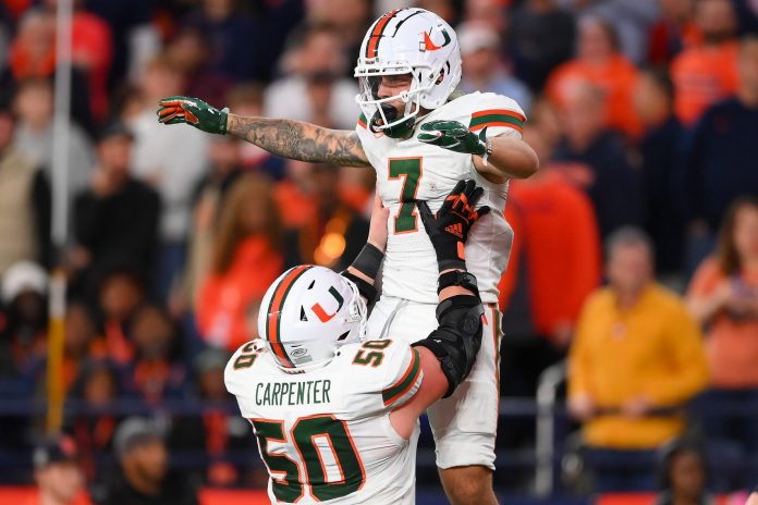 Miami Hurricanes wide receiver Xavier Restrepo (7) celebrates an offensive play with teammate center Zach Carpenter (50) against the Syracuse Orange during the second half at the JMA Wireless Dome.