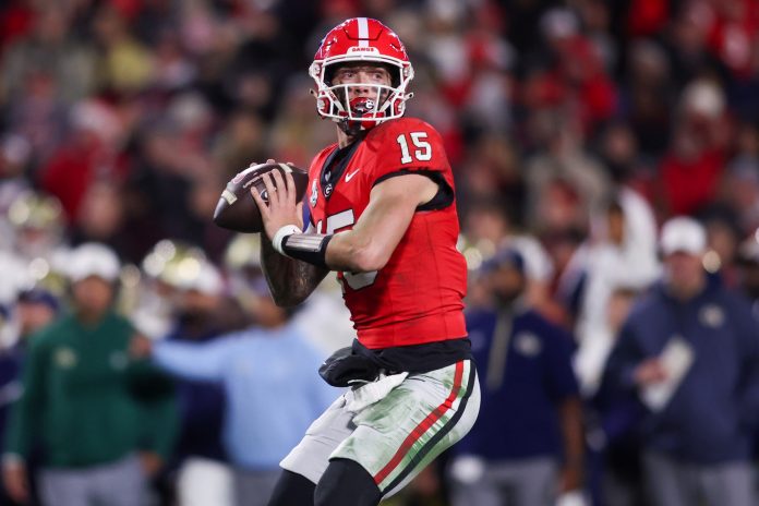 Georgia Bulldogs quarterback Carson Beck (15) throws a pass against the Georgia Tech Yellow Jackets in the fourth quarter at Sanford Stadium.