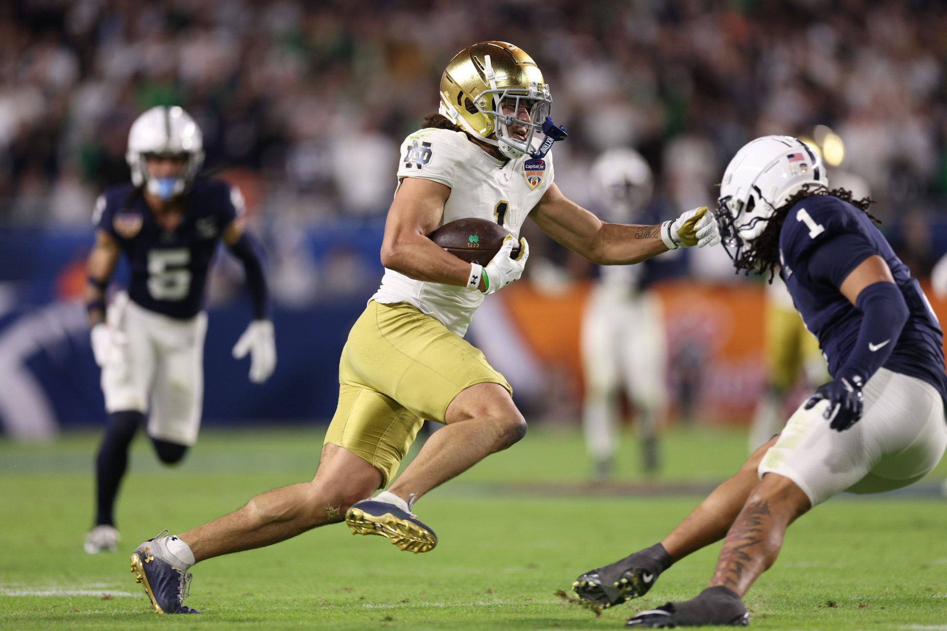 Notre Dame Fighting Irish wide receiver Jaden Greathouse (1) runs the ball pressured by Notre Dame Fighting Irish safety Jordan Clark (1) in the second half in the Orange Bowl at Hard Rock Stadium.