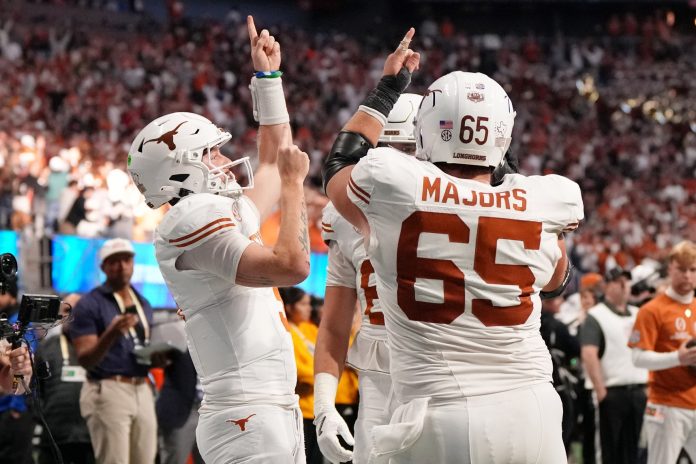 Texas Longhorns quarterback Quinn Ewers (3) celebrates with teammates after scoring a touchdown against the Arizona State Sun Devils during the second half of the Peach Bowl at Mercedes-Benz Stadium.