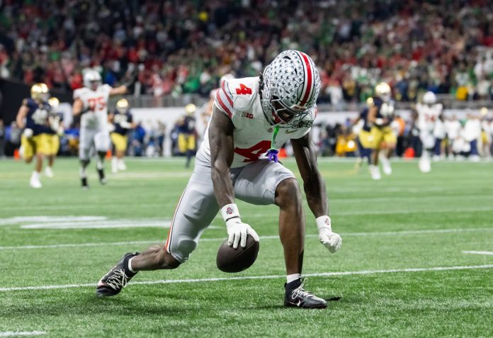 Ohio State Buckeyes wide receiver Jeremiah Smith (4) celebrates a play against the Notre Dame Fighting Irish during the CFP National Championship college football game at Mercedes-Benz Stadium.