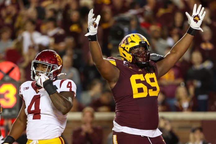 Minnesota Golden Gophers offensive lineman Aireontae Ersery (69) celebrates quarterback Max Brosmer's (16) touchdown against the USC Trojans during the first half at Huntington Bank Stadium.