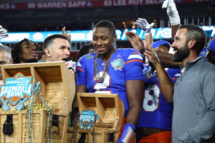 Florida Gators quarterback DJ Lagway (2) is presented the MVP trophy after the win against the Tulane Green Wave at Raymond James Stadium.