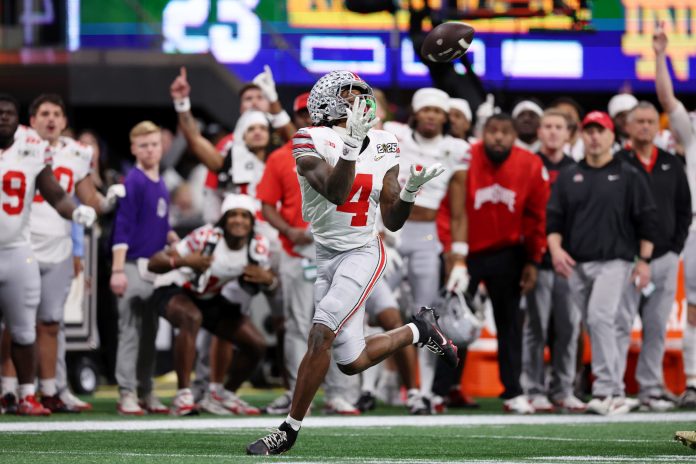 Ohio State Buckeyes wide receiver Jeremiah Smith (4) makes a catch against the Notre Dame Fighting Irish during the second half the CFP National Championship college football game at Mercedes-Benz Stadium.