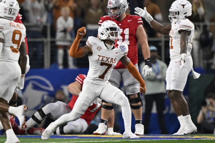 Texas Longhorns defensive back Jahdae Barron (7) celebrates after a sack during the second quarter of the College Football Playoff semifinal against the Ohio State Buckeyes in the Cotton Bowl at AT&T Stadium.