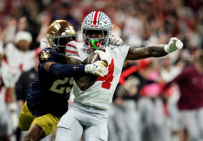 Ohio State Buckeyes wide receiver Jeremiah Smith (4) makes a catch against Notre Dame Fighting Irish cornerback Christian Gray (29) in the fourth quarter during the College Football Playoff National Championship at Mercedes-Benz Stadium in Atlanta on January 20, 2025.