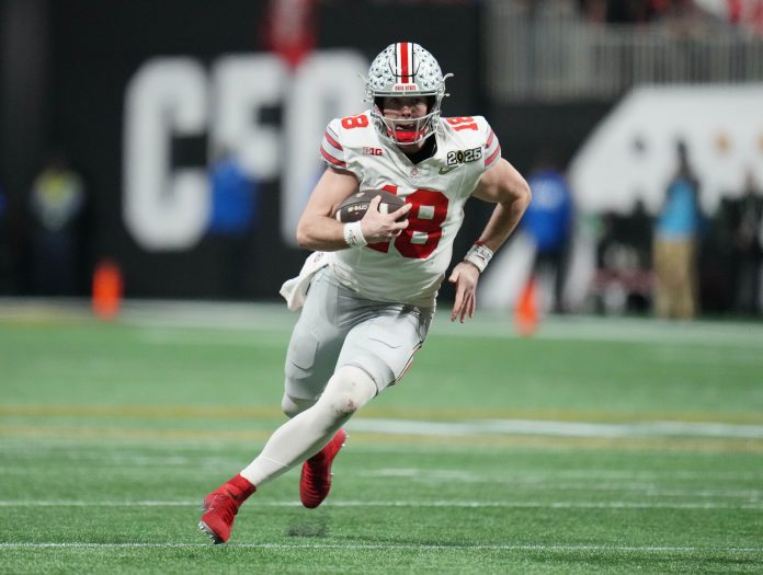 Ohio State Buckeyes quarterback Will Howard (18) runs the ball against the Notre Dame Fighting Irish in the second half in the CFP National Championship college football game at Mercedes-Benz Stadium.