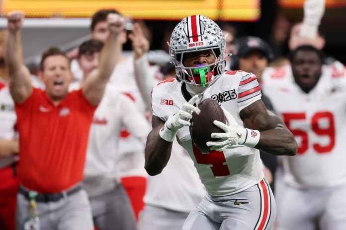 Ohio State Buckeyes wide receiver Jeremiah Smith (4) makes a catch against the Notre Dame Fighting Irish during the second half the CFP National Championship college football game at Mercedes-Benz Stadium.