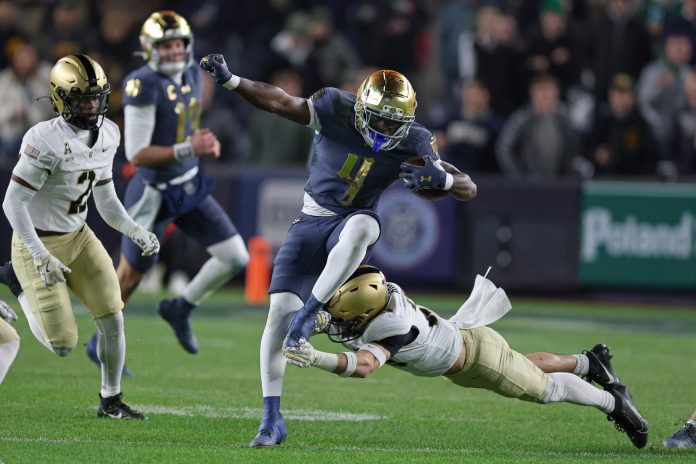 Notre Dame Fighting Irish running back Jeremiyah Love (4) carries the ball as Army Black Knights defensive back Chance Keith (2) pursues at Yankee Stadium.