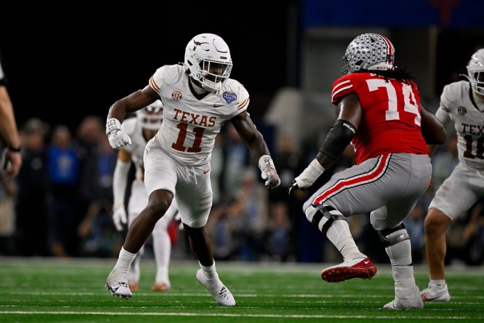 Texas Longhorns linebacker Colin Simmons (11) and Ohio State Buckeyes offensive lineman Donovan Jackson (74) in action during the game between the Texas Longhorns and the Ohio State Buckeyes at AT&T Stadium.