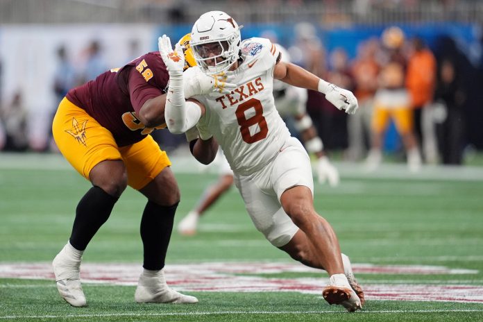 Texas Longhorns linebacker Trey Moore (8) runs around Arizona State Sun Devils offensive lineman Max Iheanachor (58) during the first half of the Peach Bowl at Mercedes-Benz Stadium.