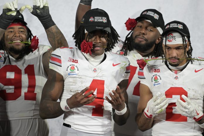 Ohio State Buckeyes wide receiver Emeka Egbuka (2) and wide receiver Jeremiah Smith (4) celebrate on the podium after defeating the Oregon Ducks in the 2025 Rose Bowl college football quarterfinal game at Rose Bowl Stadium.