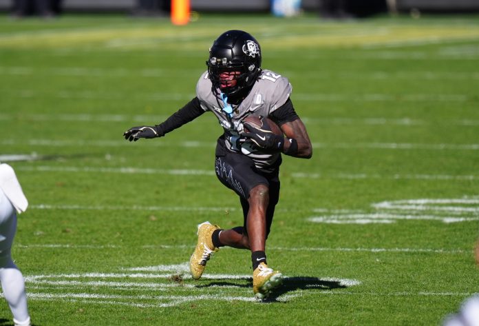 Colorado Buffaloes wide receiver Travis Hunter (12) carries the ball in the second quarter against the Utah Utes at Folsom Field.