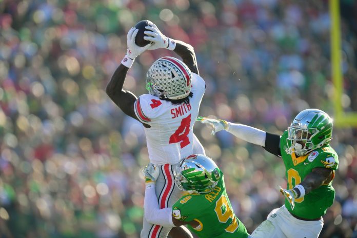 Ohio State Buckeyes wide receiver Jeremiah Smith (4) makes a catch against Oregon Ducks defensive back Nikko Reed (9) and defensive back Tysheem Johnson (0) in the 2025 Rose Bowl college football quarterfinal game at Rose Bowl Stadium.