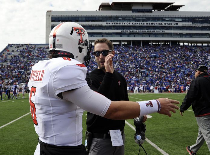 Texas Tech Red Raiders head coach Kliff Kingsbury (right) talks to quarterback Baker Mayfield (6) after a score against the Kansas Jayhawks in the second half at Memorial Stadium. Texas Tech won the game 54-16.