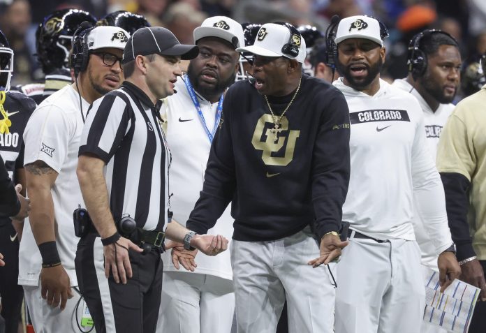 Colorado Buffaloes head coach Deion Sanders reacts with an official after a play during the second quarter against the Brigham Young Cougars at Alamodome.