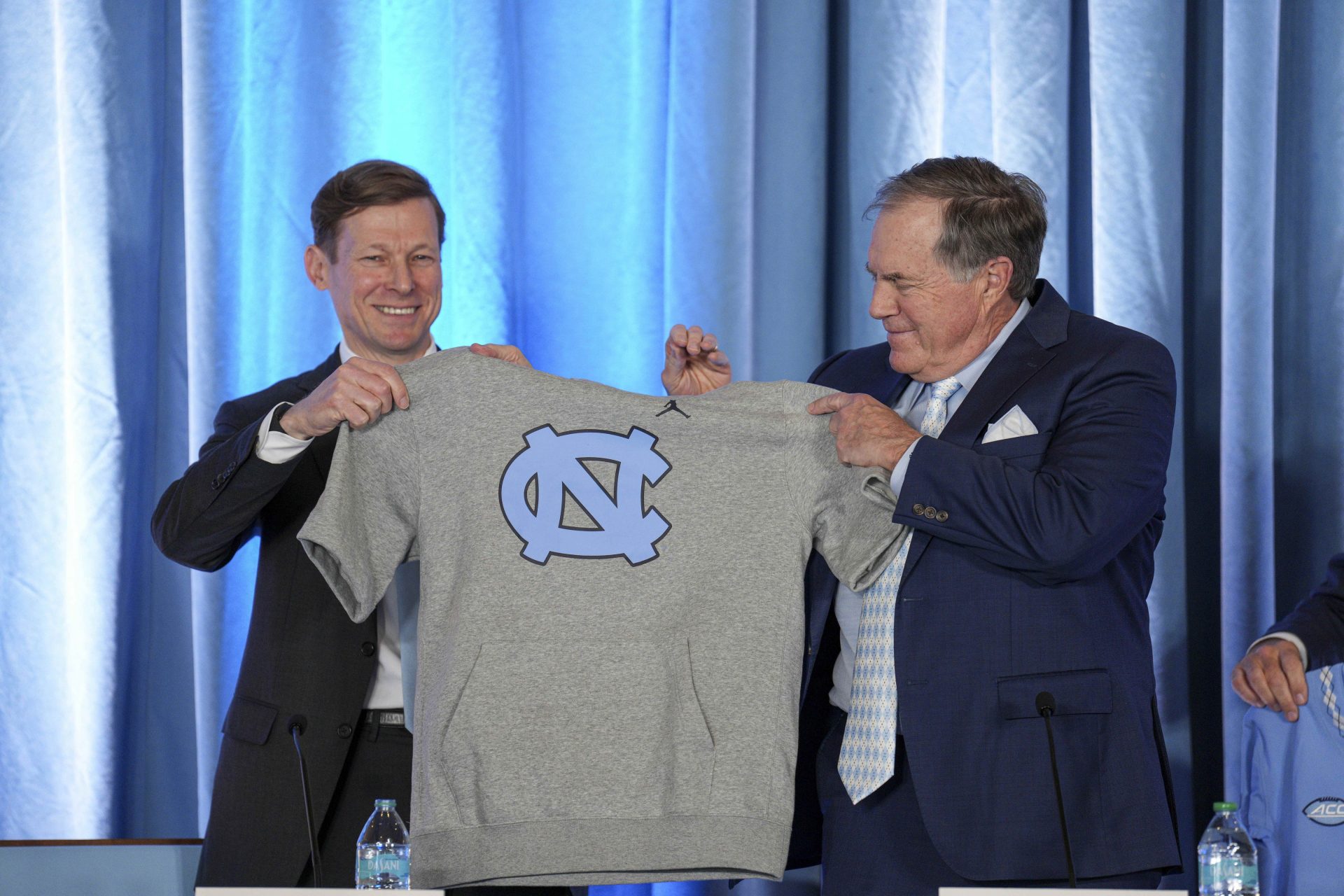 North Carolina Tar Heels chancellor Lee Roberts presents a cut off sweatshirt to new head coach Bill Belichick at Loudermilk Center for Excellence.