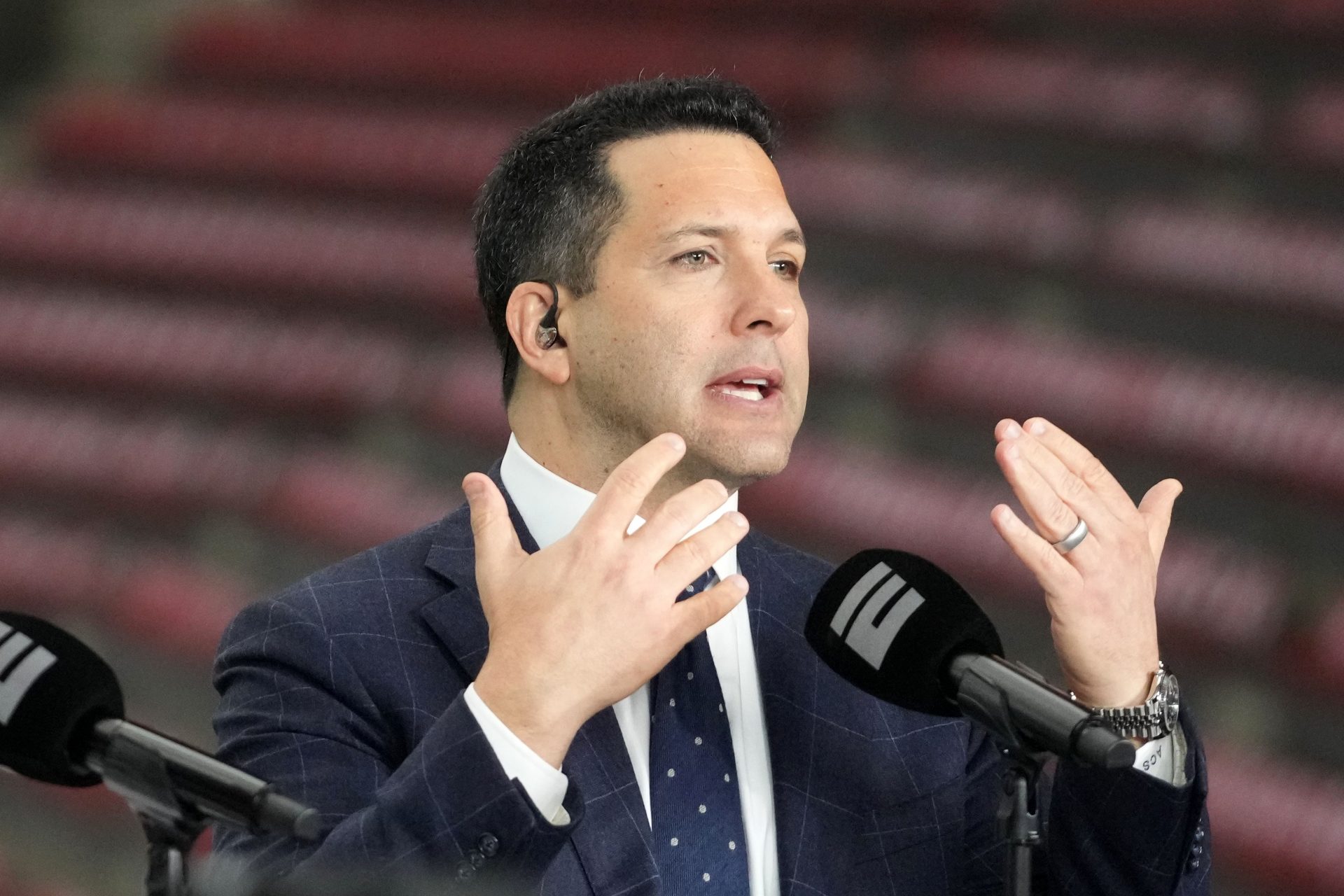 Adam Schefter talks on a set before the 2024 College Football Playoff national championship game between the Michigan Wolverines and the Washington Huskies at NRG Stadium.