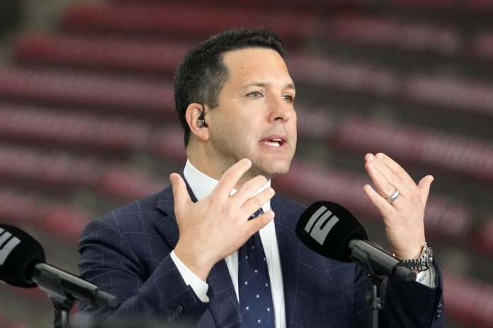 Adam Schefter talks on a set before the 2024 College Football Playoff national championship game between the Michigan Wolverines and the Washington Huskies at NRG Stadium.