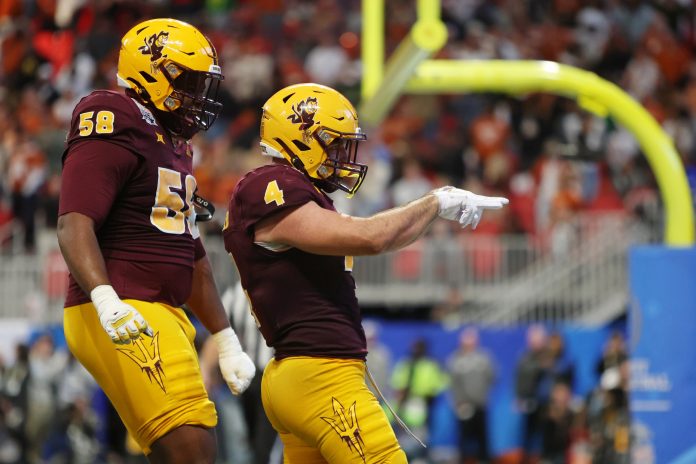 Arizona State Sun Devils running back Cam Skattebo (4) celebrates with offensive lineman Max Iheanachor (58) after scoring a touchdown against the Texas Longhorns during the second half of the Peach Bowl at Mercedes-Benz Stadium.