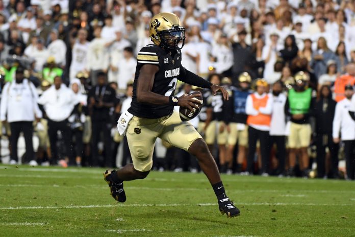 Colorado Buffaloes quarterback Shedeur Sanders (2) scrambles for a short gain during the first half against the Baylor Bears at Folsom Field.