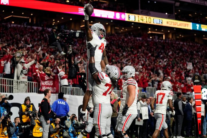 Ohio State Buckeyes wide receiver Jeremiah Smith (4) celebrates with offensive lineman Donovan Jackson (74) after a touchdown catch against Notre Dame Fighting Irish in the first quarter during the College Football Playoff National Championship at Mercedes-Benz Stadium in Atlanta on January 20, 2025.