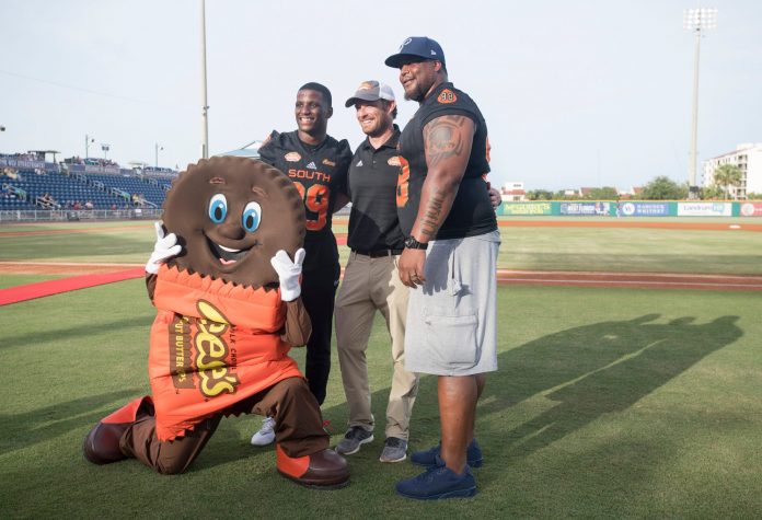 Reese’s mascot Cuppy, from left, Jeremy Reaves, Jim Nagy, and Fred Robbins pose for a photo during Reese’s Senior Bowl Night at Blue Wahoos Stadium in Pensacola on Wednesday, June 26, 2019.