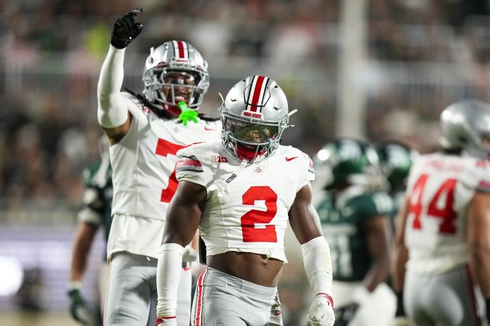 Ohio State Buckeyes safety Caleb Downs (2) celebrates after tackling Michigan State Spartans running back Nate Carter (5) in the first half at Spartan Stadium on Saturday.