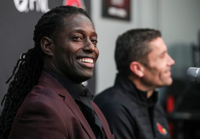 Louisville interim head football coach Deion Branch smiles Monday afternoon, as Louisville AD Josh Heird talks in the background. Just a few hours earlier, former coach Scott Satterfield was announced as head coach at Cincinnati. Branch said he is only coaching the upcoming Fenway Bowl game; Branch is currently director of player development for UofL. Dec. 5, 2022