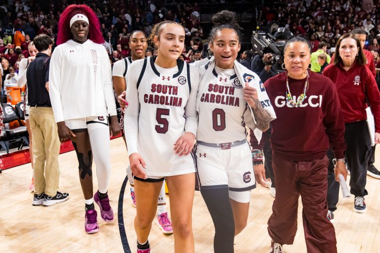 South Carolina Gamecocks guard Tessa Johnson (5), guard Te-Hina Paopao (0), and head coach Dawn Staley celebrate their win over the LSU Lady Tigers at Colonial Life Arena.