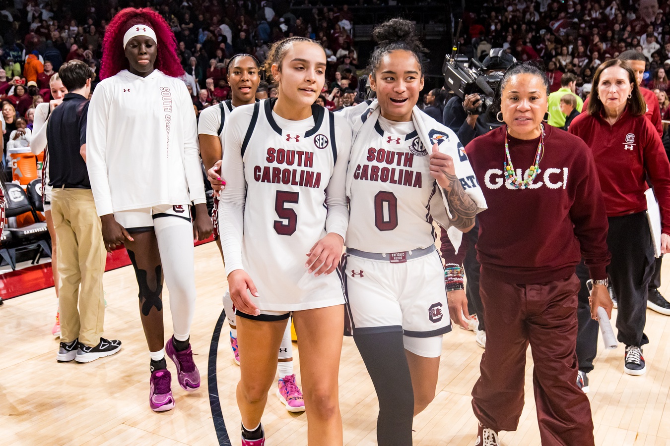 South Carolina Gamecocks guard Tessa Johnson (5), guard Te-Hina Paopao (0), and head coach Dawn Staley celebrate their win over the LSU Lady Tigers at Colonial Life Arena.
