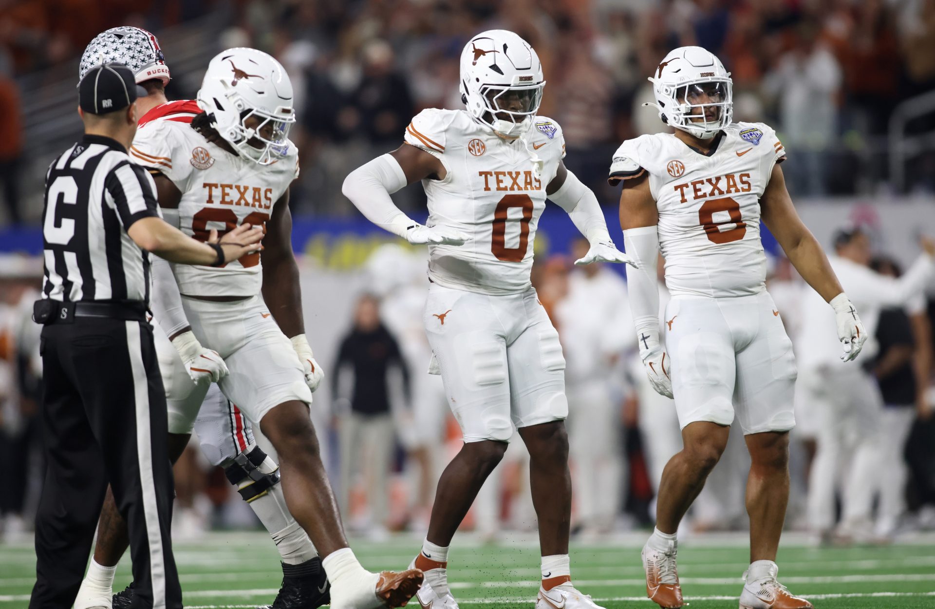 Texas Longhorns linebacker Anthony Hill Jr. (0) celebrates with linebacker Barryn Sorrell (88) and linebacker Trey Moore (8) after a play during the second quarter of the College Football Playoff semifinal against the Ohio State Buckeyes in the Cotton Bowl at AT&T Stadium.