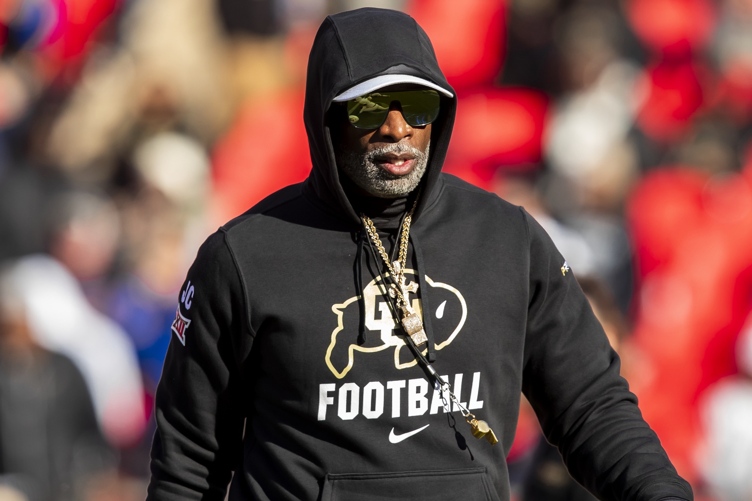 Colorado head coach Deion Sanders watches his players warmup prior to the game between the Kansas Jayhawks and the Colorado Buffaloes at GEHA Field at Arrowhead Stadium.