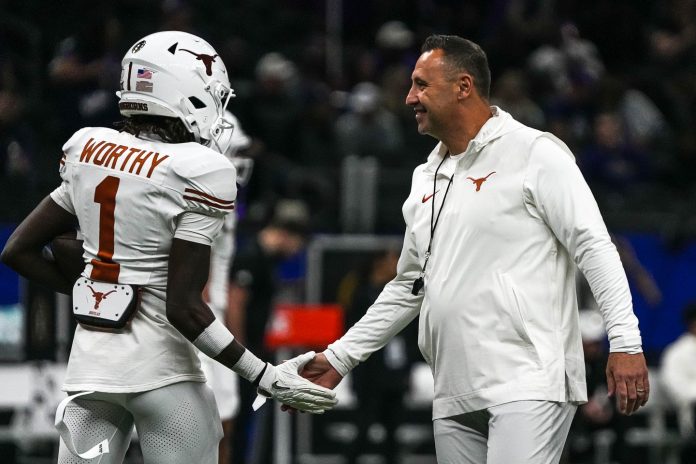 Texas Longhorns head coach Steve Sarkisian greets wide receiver Xavier Worthy (1) while warming up for the Sugar Bowl College Football Playoff semifinals game against the Washington Huskies at the Caesars Superdome on Monday, Jan. 1, 2024 in New Orleans, Louisiana.