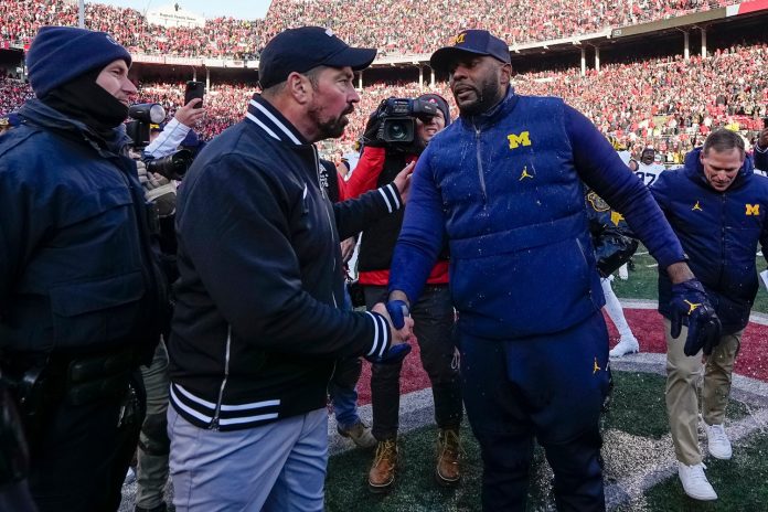 Ohio State Buckeyes head coach Ryan Day shakes hands with Michigan Wolverines head coach Sherrone Moore following Michigan's 13-10 victory.