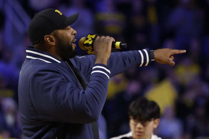 Michigan Wolverines head coach football Sherrone Moore addresses the crowd during a basketball game against the Iowa Hawkeyes at Crisler Center.