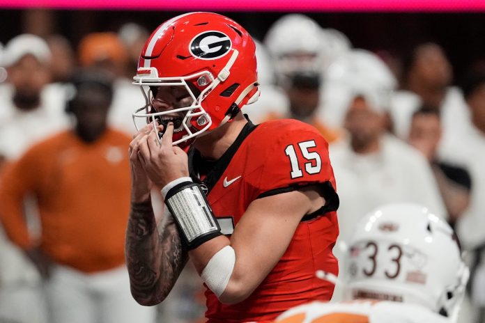 Georgia quarterback Carson Beck (15) putts in his mouth grad on the final play during overtime of the SEC championship game against Texas in Atlanta, on Saturday, Dec. 7, 2024.