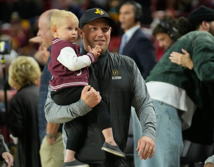 Arizona State head football coach Kenny Dillingham holds his son, Kent, while watching Big 12 basketball between Arizona State and Houston at Desert Financial Arena in Tempe, on Feb. 18, 2025.