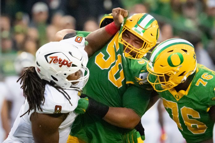 Oregon offensive linemen Nishad Strother, center, and Josh Conerly Jr., right, engage Maryland defensive lineman Jordan Phillips as the Oregon Ducks host the Maryland Terrapins at Autzen Stadium Saturday, Nov. 9, 2024 in Eugene, Ore.