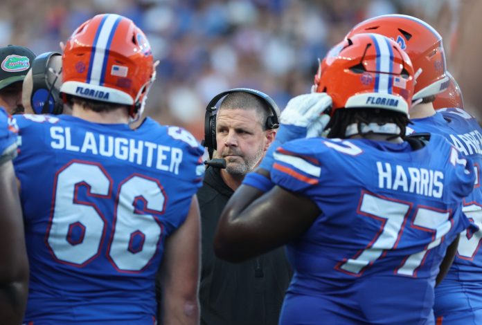 Florida Gators head coach Billy Napier huddles up with teammates against the LSU Tigers during the first half at Ben Hill Griffin Stadium.