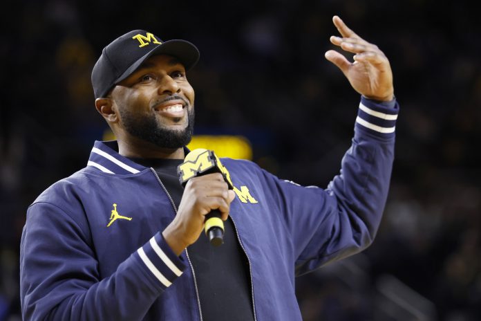 Michigan Wolverines head football coach Sherrone Moore fires up the crowd in overtime of the basketball game against the Northwestern Wildcats at Crisler Center.