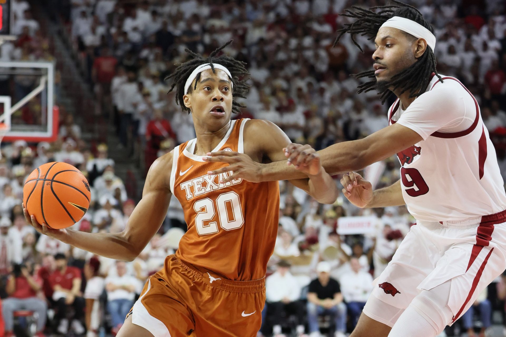 Texas Longhorns guard Tre Johnson (20) drives against Arkansas Razorbacks forward Jonas Aidoo (9) during the second half at Bud Walton Arena.