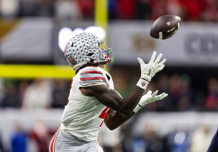 Ohio State Buckeyes wide receiver Jeremiah Smith (4) catches a pass against the Notre Dame Fighting Irish during the CFP National Championship college football game at Mercedes-Benz Stadium.