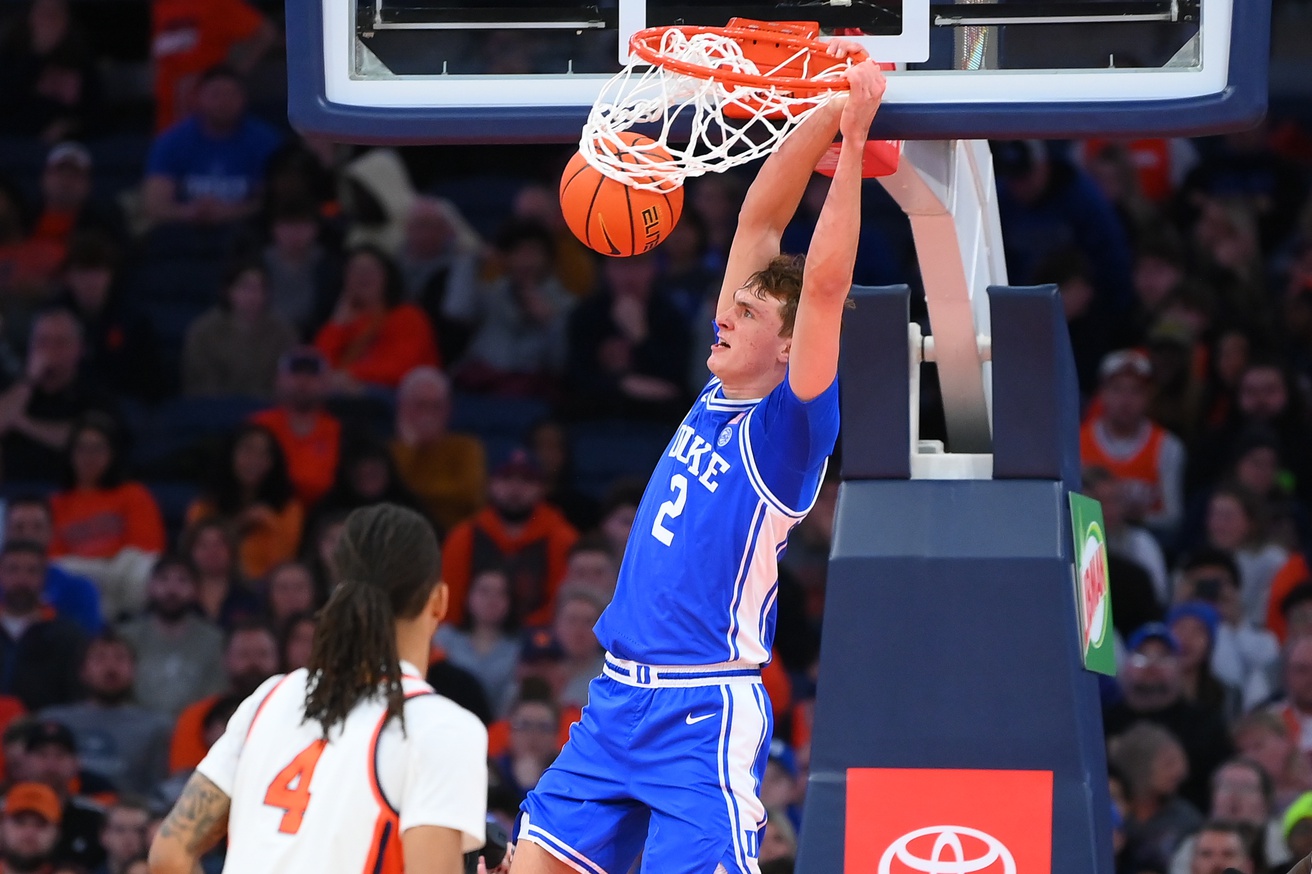 Duke Blue Devils guard Cooper Flagg (2) dunks as Syracuse Orange forward Chris Bell (4) defends during the second half at the JMA Wireless Dome.