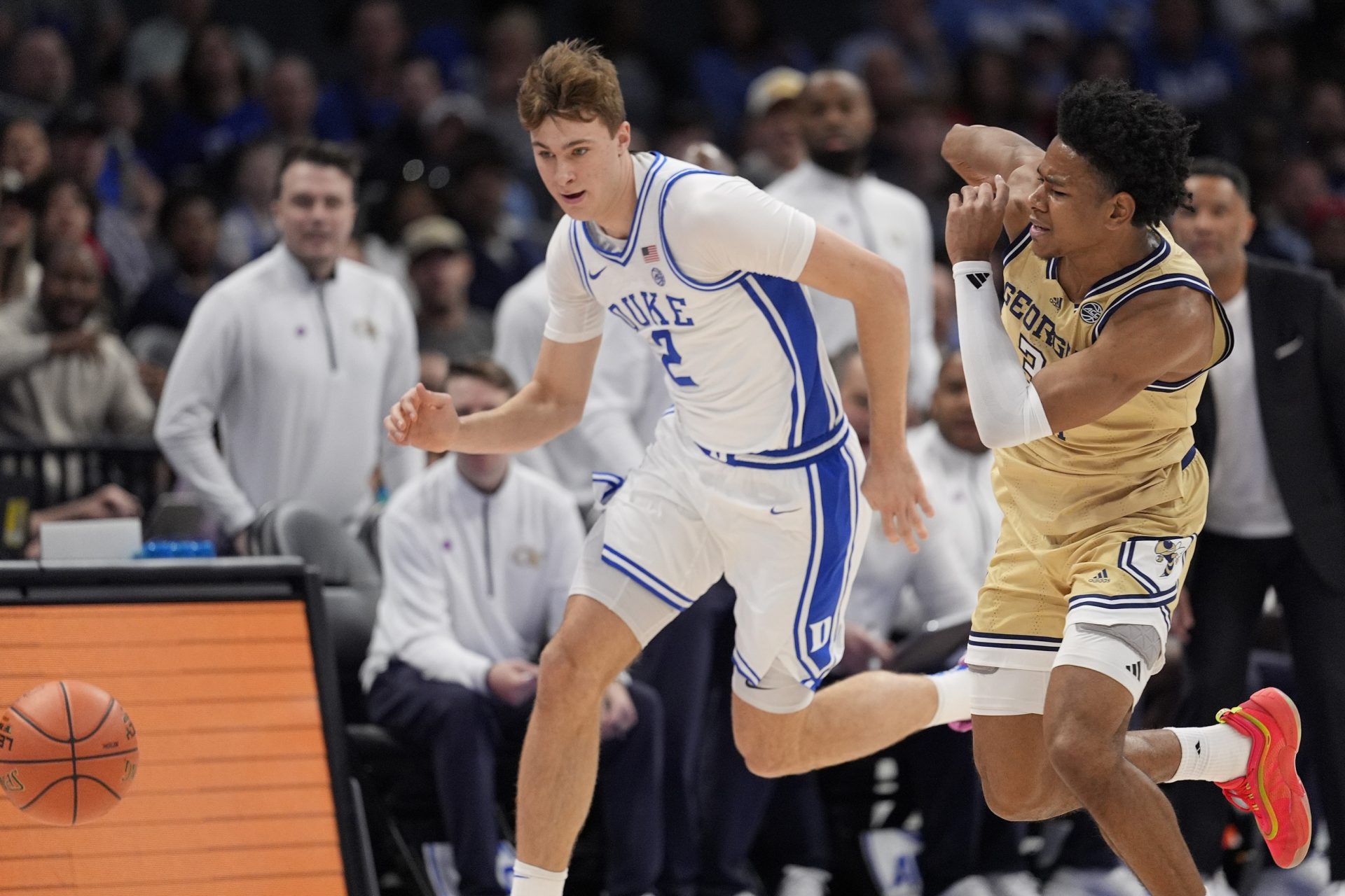 Duke Blue Devils forward Cooper Flagg (2) and Georgia Tech Yellow Jackets guard Jaeden Mustaf (3) chase the loose ball during the first half at Spectrum Center.